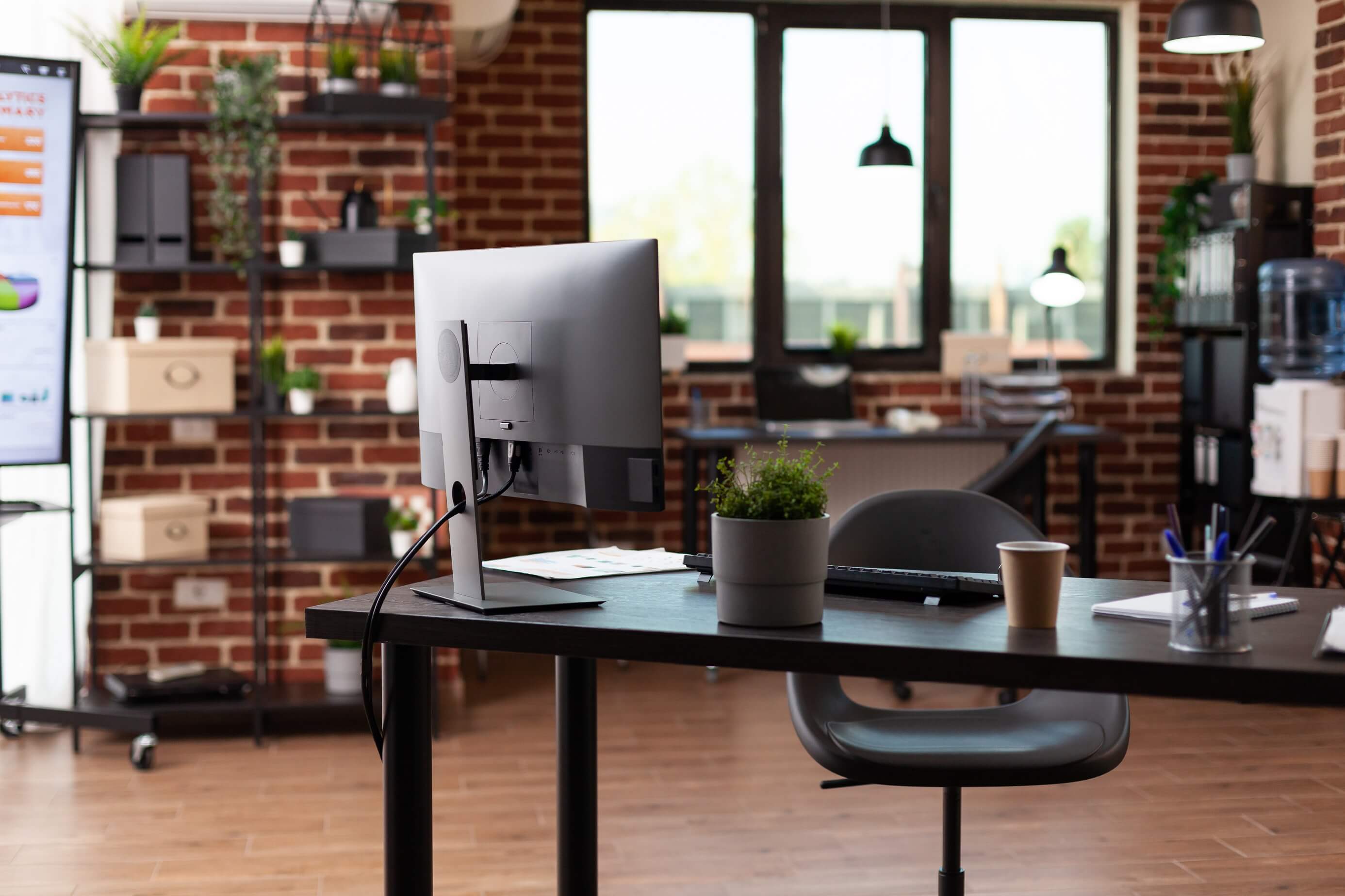 Photo of an empty office with desks and plants.