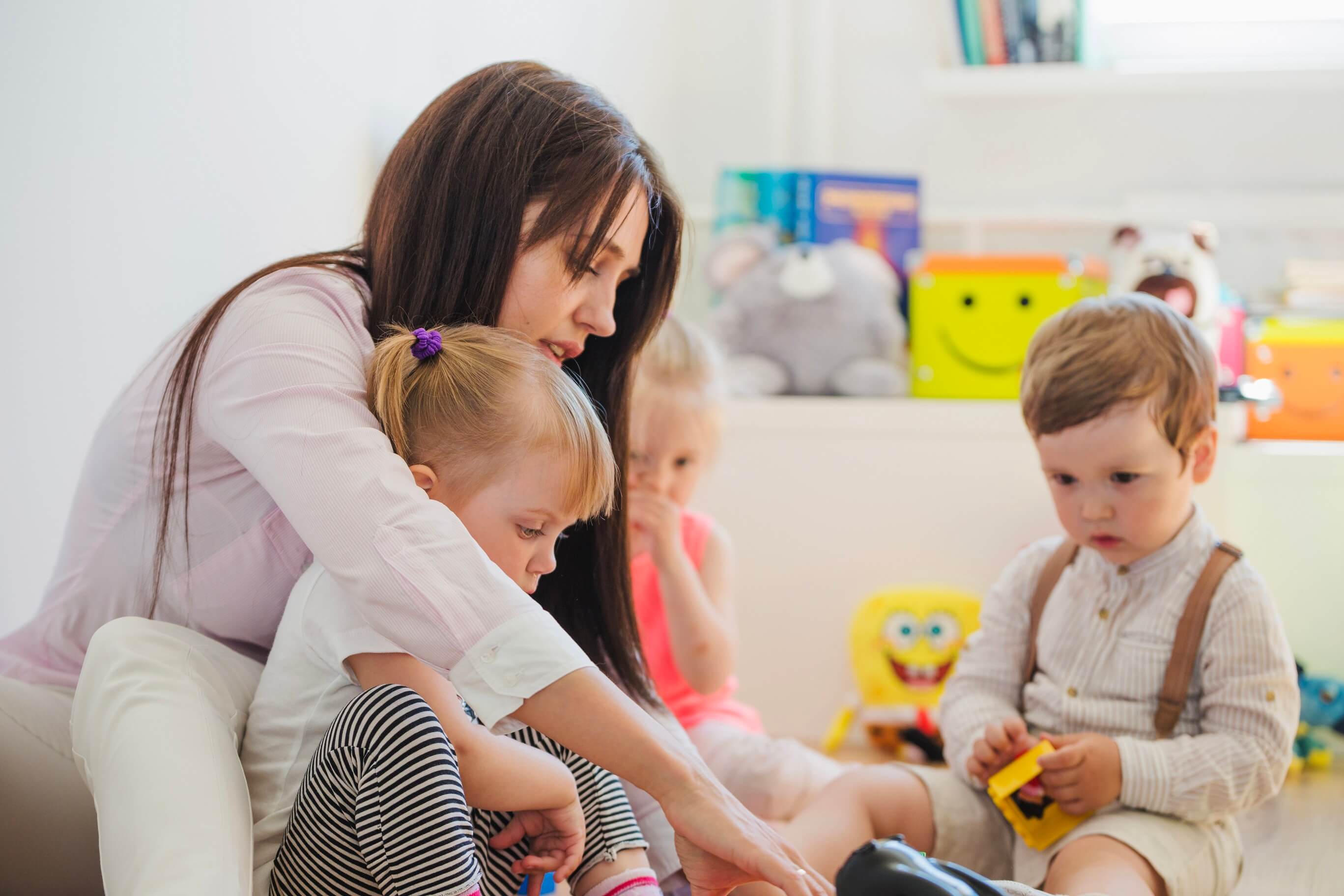 Daycare teacher playing with two children
